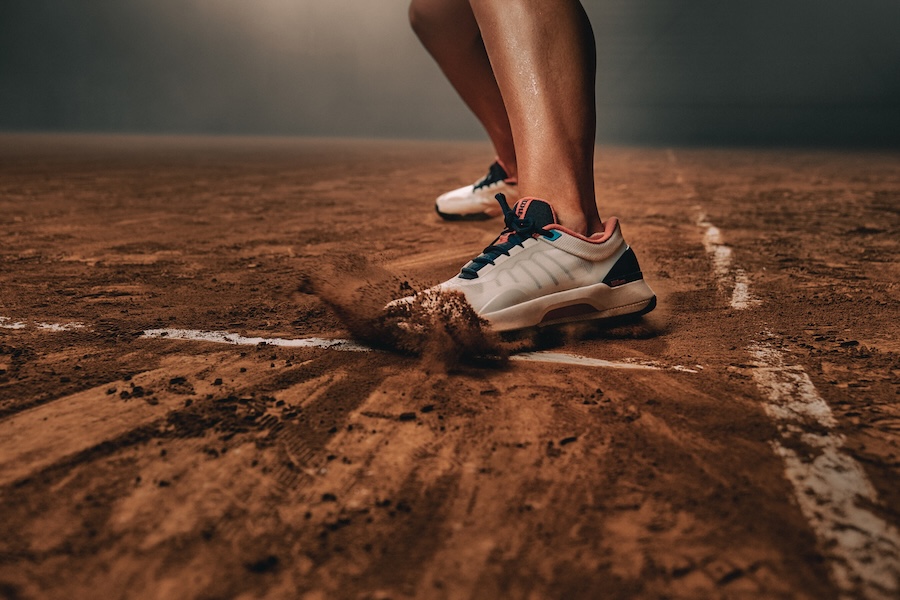 picture of The Intrigue tennis shoe on player sliding on clay court