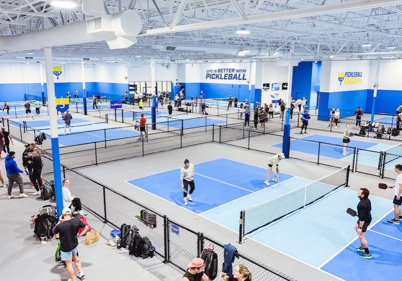 Interior view of a Pickleball Kingdom club, featuring multiple professional-grade indoor courts.